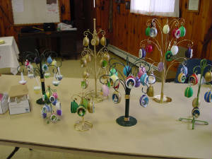 on a table are several display stands showing various holiday themed egg ornaments 